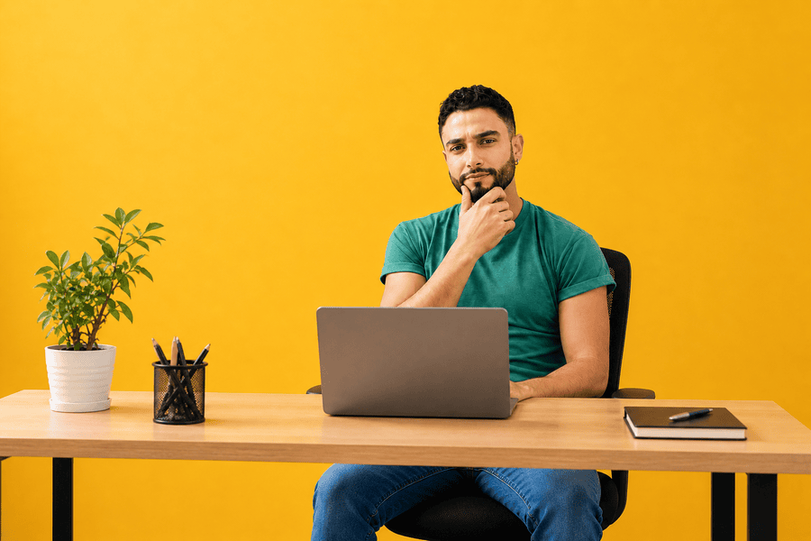 Man working on a laptop at a desk, representing planning and budgeting for a small business website